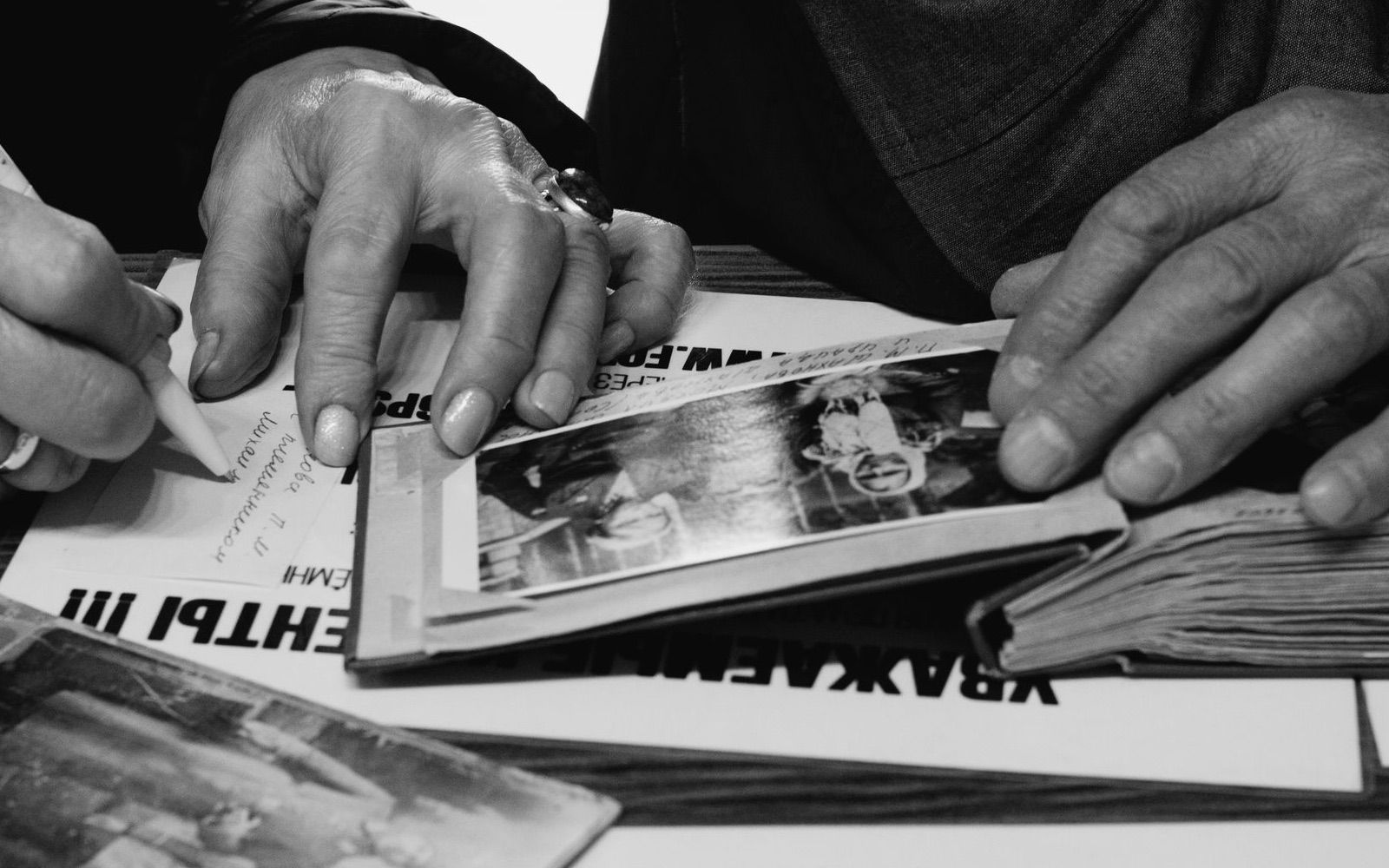 Older relatives reviewing and annotating a family photo album